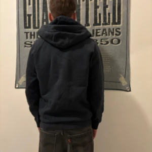 Mörkblå hoodie från Peak Performance - Säljer en snygg mörkblå hoodie från Peak Performance i bra skick. Den har en dragkedja framtill och en praktisk huva. Perfekt för både vardag och träning. Storleken är normal och den har långa ärmar. Passar perfekt till jeans eller träningsbyxor!( visar sig vara L men passar till mindre, bevis är mig själv).