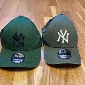 Fyra kepsar från New Era - Säljer fyra kepsar från New Era i olika färger och stilar. Två gröna kepsar med NY-logga, en svart keps med pantermotiv och en blå keps med LA-logga. Alla kepsar är i justerbar storlek och har klassisk design. Perfekta för både vardag och sportiga aktiviteter! Seljer 50 st pris, och alla för 150