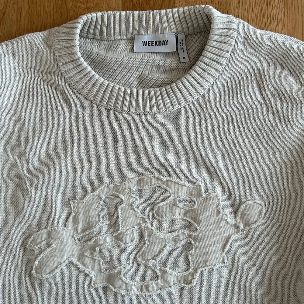Vit stickad tröja från Weekday. Den har ett coolt broderat mönster på framsidan och ribbade muddar vid ärmslut och nederkant. Perfekt för en stilren vinter. Passar både till vardags och fest!. Neuletakit & Villapaidat.