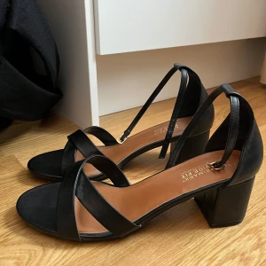 Svarta sandaler från Primark - Snygga svarta sandaler från Primark i storlek 42. De har en bred passform för extra komfort och en stilren design med korsade remmar och en bekväm klack. Perfekta för både vardag och fest!