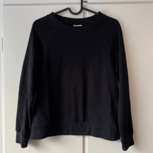 Svart sweatshirt - Säljer en stilren svart sweatshirt i bra skick. Den är perfekt för både vardag och chill med sin bekväma passform och mjuka material. Tröjan har långa ärmar och en klassisk rund halsringning. Tröjan är lite nopprig men det kan säkert en noppborttagare enkelt ta bort!