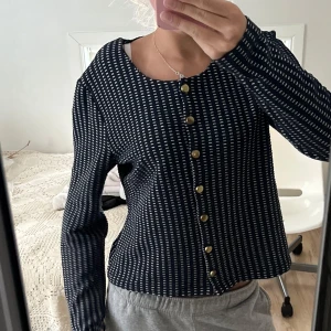 Blå och vit mönstrad kofta - Säljer en snygg blå och vit mönstrad kofta med guldknappar. Den har långa ärmar och en normal passform, perfekt för både vardag och fest. Koftan är i mycket bra skick och passar perfekt till höst- och vårgarderoben. 🖤🤍