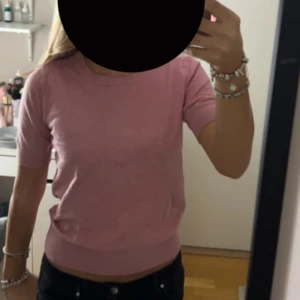Rosa kortärmad tröja - Säljer en söt stickad rosa kortärmad tröja i mjukt material. Perfekt för alla tillfällen! Tröjan har en normal passform och är superbekväm. Passar både till jeans och kjol för en avslappnad look. 🌸