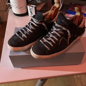 Mörby blåa mocha Phillippe models - Säljer ett par snygga blå sneakers från Philippe Model i bra skick. De har en klassisk design med vita snören som har liver avfärjade från mochan och en vit sula. Skorna är bekväma och stilrena, vilket gör dem till ett måste i garderoben. Passa på att fynda dessa kvalitetskor! Skriv om vilka frågor som hälst