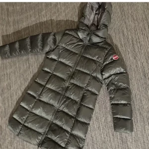 Glimrig grön dunjacka från Colmar - Säljer en snygg och varm glimrande grön dunjacka från Colmar. Jackan har en lång modell med huva och dragkedja framtill. Perfekt för kalla vinterdagar. Den är i mycket bra skick och redo för nya äventyr! 🧥❄️