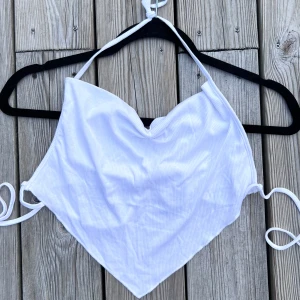 Vit topp med snörning - En vit liten topp med snöre runt nacken och knytning runt midjan - ingen baksida! Gullig topp inför sommaren, utlandsresan eller utekvällen 💜  (ALDRIG ANVÄND)  Längd: 42 cm Byst: 95 cm