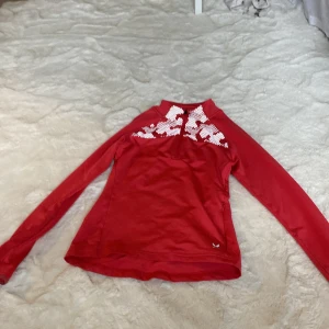 Röd långärmad tröja med mönster - Säljer en snygg röd tröja med ett coolt vitt mönster över bröstet. Den är långärmad och perfekt för kyligare dagar. Tröjan är i bra skick och passar både till vardags och lite mer avslappnade tillfällen. Perfekt för dig som vill ha något bekvämt men ändå stiligt! 🔥