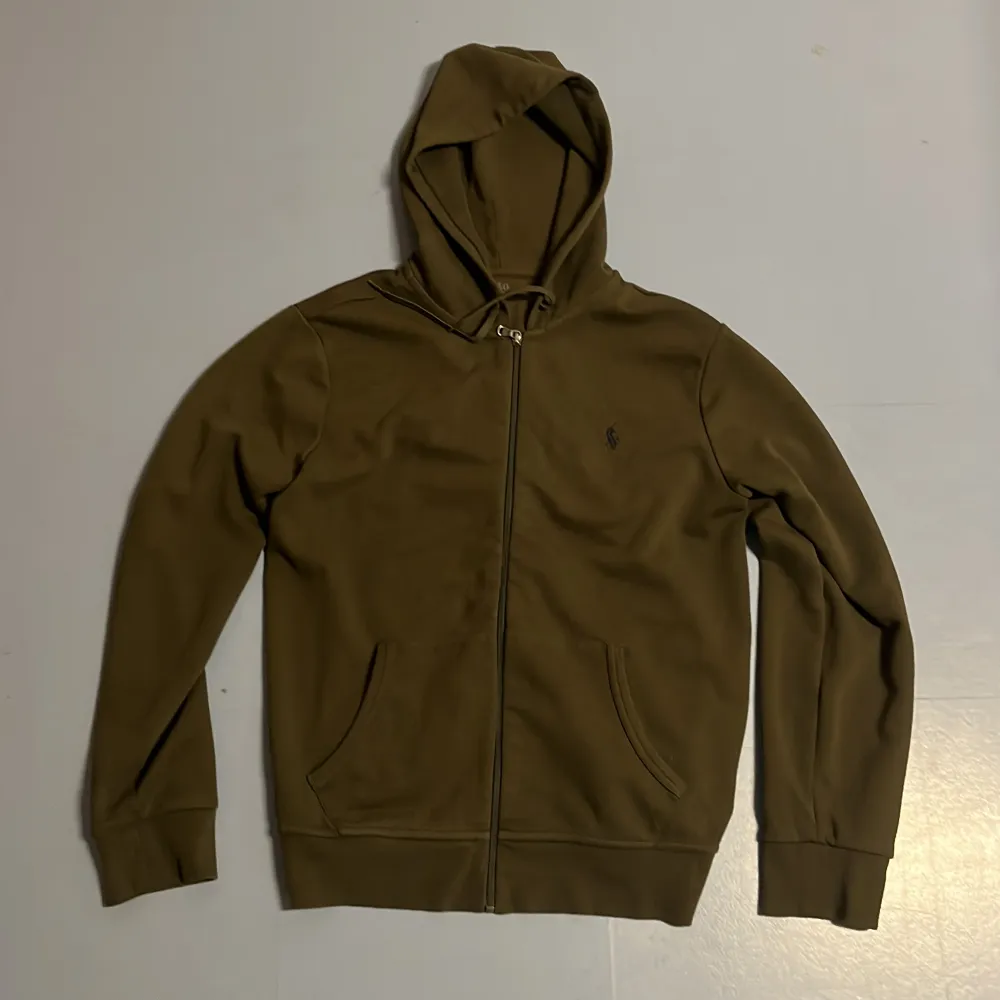 Tja säljer nu en riktigt snygg Ralph Lauren zip Hoodie i storlek M och i färgen olivgrön. Nypris 2395kr mitt pris 549kr. Hoodien har inga defekter som hål eller fläckar. Hör av dig vid frågor eller funderingar.. Hoodies.