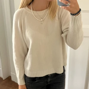 Beige stickad tröja - Säljer en supermysig vit stickad tröja som är perfekt för höst och vinter. Den har långa ärmar och en ribbad kant vid halsen och nederkanten. Tröjan passar perfekt till både jeans och kjol. Perfekt för en chill dag eller en mysig fika med vänner! 💫