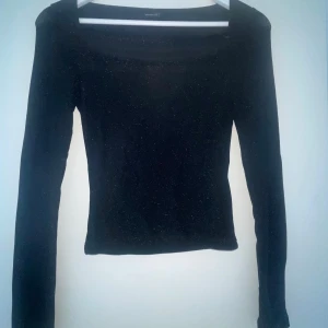 Glittrig topp - En glittrig svart Topp ifrån Gina tricot, säljer då den inte kommit till användning😊