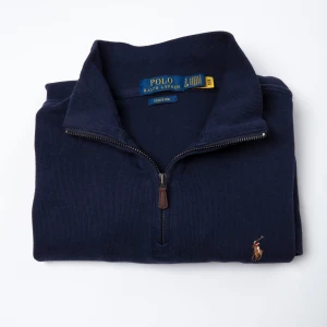 Mörkblå tröja från Polo Ralph Lauren - Nu säljer vi denna Ralph lauren half zip. Tröjan är ett perfekt varmt och mysigt plagg att ha inför hösten. Tröjan har använts ett fåtal gånger men har inga defekter eller fel. Skick: 9/10. Nypris: 2195 kr. Om du har några frågor, tveka inte att kontakta oss. ( Självtagna bilder )