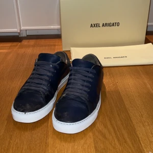Axel Arigato  - Mörkblå skor från arigato. Skick 8/10 lite slitningar här och där men ändå fräscha. Hör av dig vid frågor! Priset är inte hugget i sten