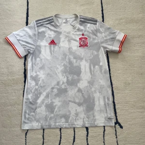 Spanien Bortatröja 2020 - Spaniens borta tröja säsongen 2020-2021. Tröjan användes även Em det året. Endast använd ett fåtal gånger. Cond: 8/10 Namn/nr: Ingen