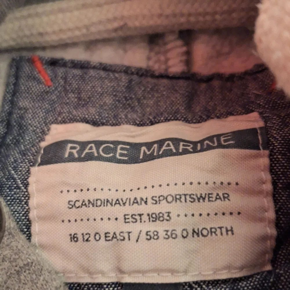 Säljer en grå hoodie från Race Marine med texten 'Scandinavian Sportswear' tryckt på framsidan. Den har en klassisk känguruficka och är perfekt för både vardag och chill. Superbekväm och stilren, passar till allt! 🖤. Hoodies.