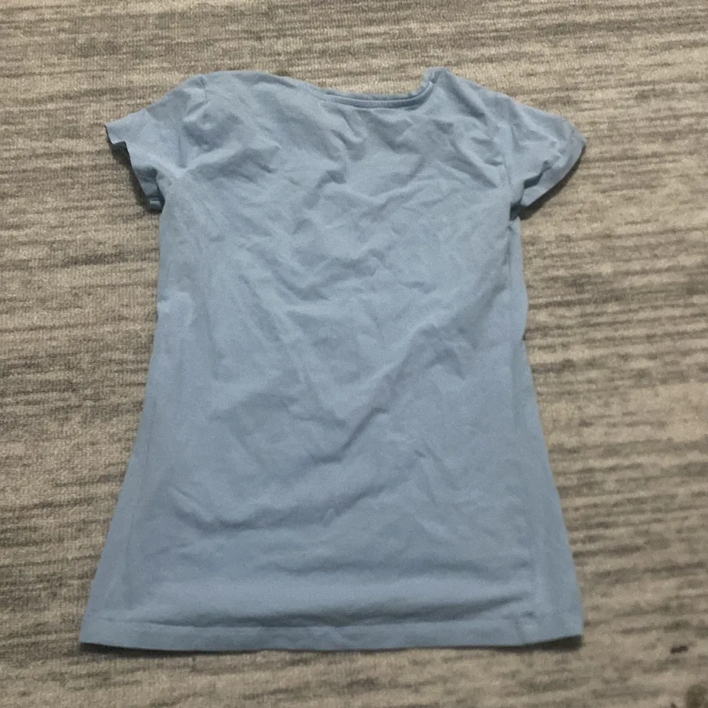 Säljer en enkel och stilren ljusblå t-shirt från Basic You i storlek XS. T-shirten har en v-ringad hals och korta ärmar, perfekt för vardagsbruk. Materialet känns mjukt och bekvämt mot huden. Passar bra till både jeans och kjol för en avslappnad look.. Yläosat.