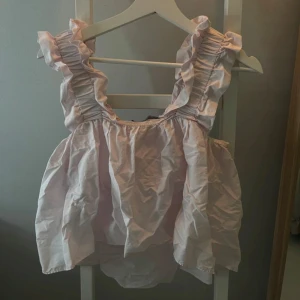 Ljusrosa topp från Zara - Säljer en söt ljusrosa topp från Zara i storlek XS. Toppen har volangdetaljer vid axlarna och är ärmlös. 