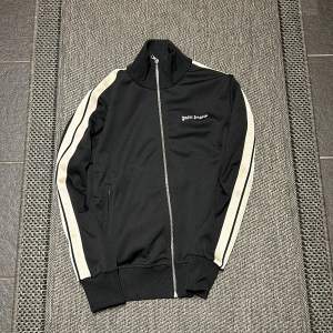 Säljer en snygg svart track jacket från Palm Angels. Köpt i sommras använd max 4 gånger skick 10/10 broderat tryck på bröstet köpt på nk i Stockholm, påse finns med, nypis 6400kr 