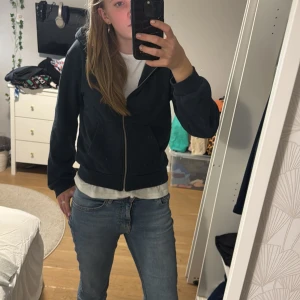 Svart hoodie med dragkedja - Säljer en svart hoodie i bra skick. Den har en dragkedja framtill och långa ärmar. Perfekt för höst och vår, och funkar till vardags eller chill dagar. Storleken är normal och den är superbekväm att ha på sig.