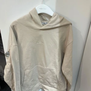 Beige hoodie från lager - Säljer en snygg beige hoodie från VND i storlek 150 passar som xs-xxs. Den är supermjuk och perfekt för både skola och chill hemma. Hoodien har en klassisk känguruficka och en bekväm passform. Perfekt för höst och vår!🫧🤍