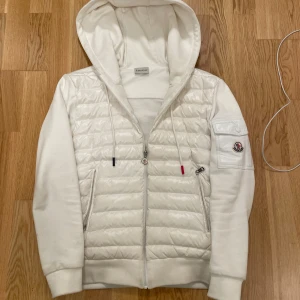 Moncler Cardigan - Säljer en snygg vit jacka från Moncler i mycket bra skick. NFC funkar samt alla taggar med! Strlk M men passar även S.