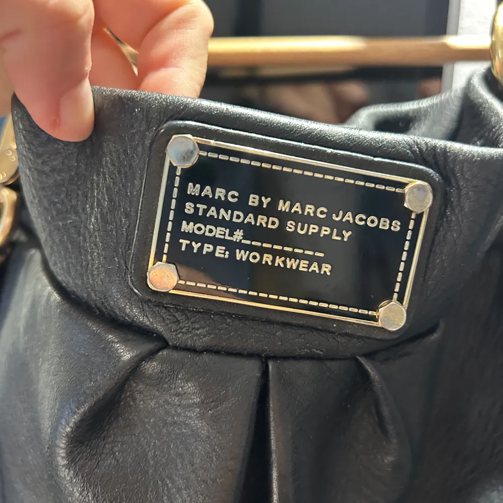 Säljer en snygg svart axelväska från Marc Jacobs i skinn. Väskan har guldfärgade detaljer och en praktisk dragkedja. . Laukut & Käsilaukut.