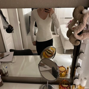 Vit långärmad topp med V ringning - Säljer en stilren vit långärmad topp i storlek XS. Den har en v-ringad design och är perfekt för både vardag och fest. Materialet är mjukt och stretchigt, vilket ger en bekväm passform. Toppen är i mycket bra skick och redo för en ny garderob!