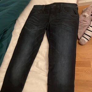 Svarta jeans från True Religion - Säljer ett par snygga svarta jeans från True Religion i storlek 28. De har en klassisk design med en mörk tvätt och är i mycket bra skick. Perfekta för både vardag och fest! 🖤