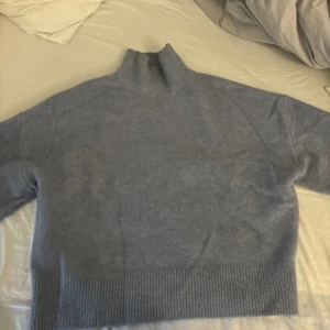 Grå stickad tröja från Zara - Säljer en supermysig grå stickad tröja från Zara som är halv polo . Tröjan har ett väldigt bra skick. Passar perfekt till både vardag och mysiga hemmakvällar.