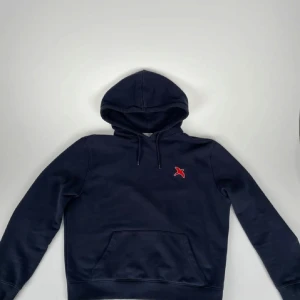 Hoodie Från Arigato - Säljer en stilren mörkblå hoodie från Axel Arigato. Skick 9/10 har inga defekter.   Nypris 1800.  Går inte att få tag på längre.