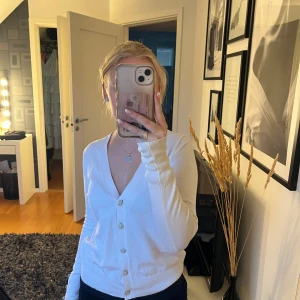 Vit kofta från Zara - Säljer en superfin vit kofta från Zara i storlek S. Den har långa ärmar och glittriga knappar som ger en lyxig touch. Perfekt för både vardag och fest! ✨