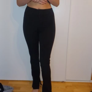 Svarta kostym byxor - Säljer ett par svarta kostym byxor i mycket bra skick. De är högmidjade och har en slim passform som framhäver figuren. Perfekta för både vardag och fest!