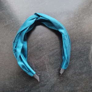 Turkost diadem - Oanvänt och snyggt turkost hårband i satinmaterial med en cool twistad design, Köpt på glitter för något år sen!