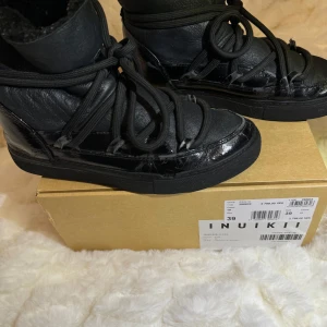 Svarta boots från Inuikii - Säljer ett par svarta Inuikii boots i storlek 39. De är i ok skick. Perfekta för höst och vinter, och de ger en snygg touch till vilken outfit som helst. Nypris 2799kr.