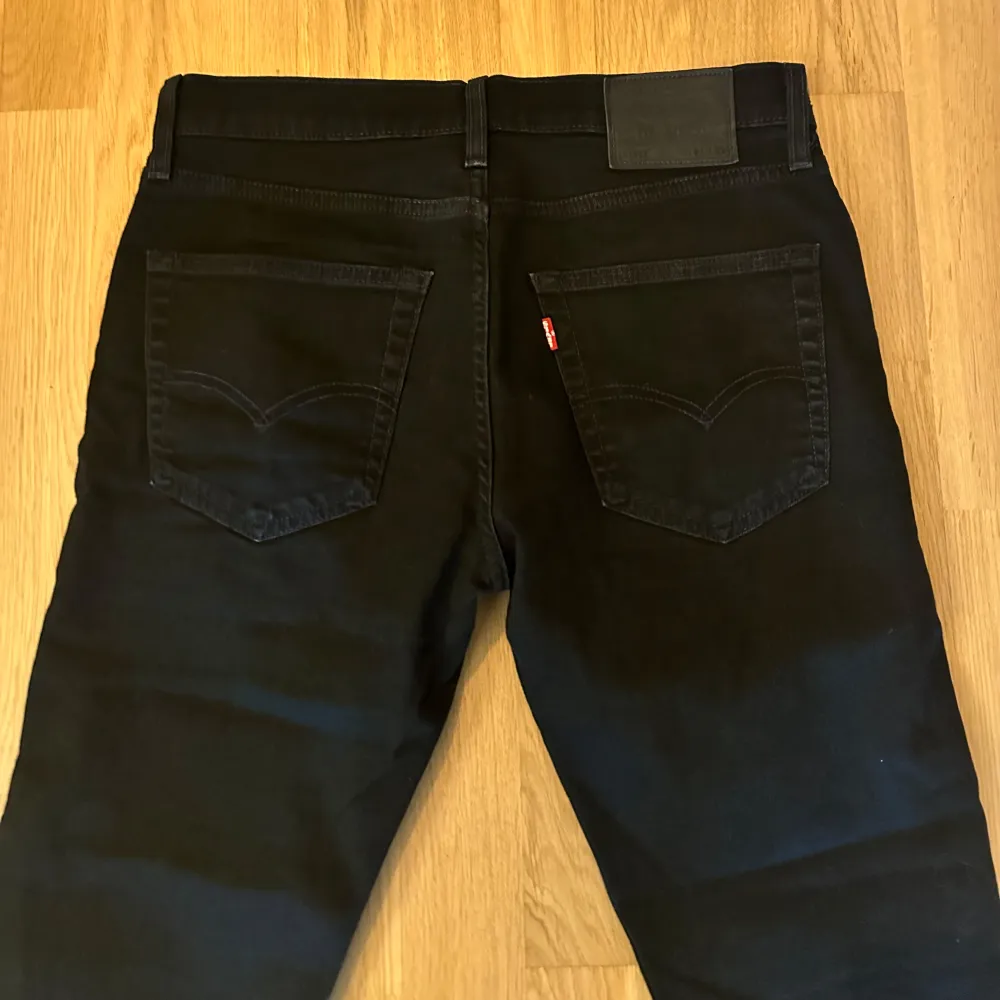 svarta jeans från Levi's med revor vid knäna.  Jeansens modell är 511 Slim Fit. Storlek 31/32. Jeans & Byxor.