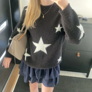 Svart tröja med stjärnor - Selling a super nice black sweater with white stars. It is perfect for both autumn and winter and has a normal fit. The sweater is long-sleeved and made of a soft material that keeps you warm. Perfect for a cozy day or a starry evening! ✨ From a shop called Meet Me There!