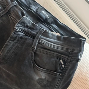 Svarta jeans från Replay - Säljer ett par snygga svarta jeans från Replay. De har en cool tvättad look och är i mycket bra skick. Perfekta för både vardag och fest! Passformen är slim och de har klassiska fem fickor. Sköna och stilrena, ett måste i garderoben!