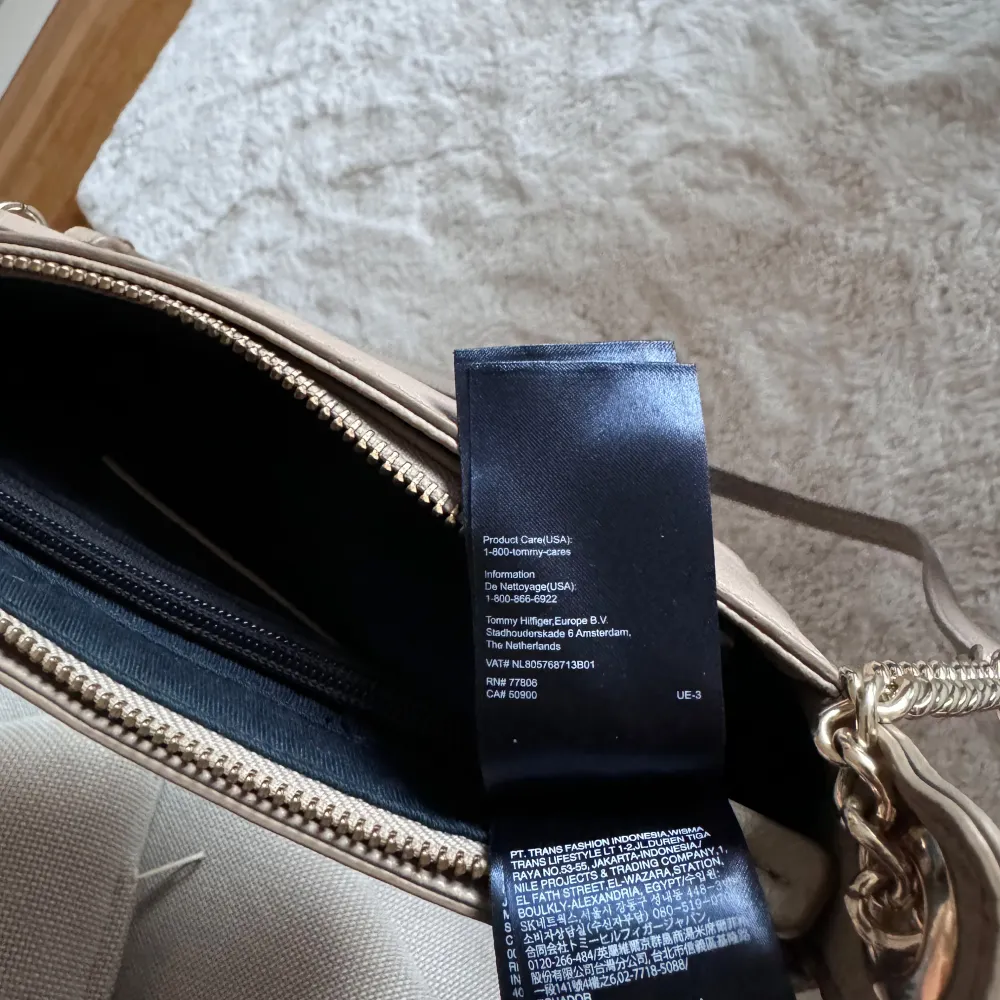 Säljer en snygg beige axelväska från Tommy Hilfiger i mycket bra skick. Väskan har en stilren design med en kedjedetalj på axelremmen och en praktisk dragkedja upptill. Perfekt för både vardag och fest!. Laukut & Käsilaukut.