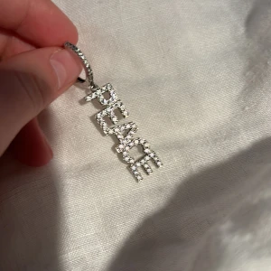 Ioaku 'PEACE' örhänge - Snygga och trendiga örhängen i silver med glittrande stenar som bildar ordet 'PEACE'. Säljer då den inte kommer till användning! Kan diskutera pris vid snabb affär. Säljer bara ett örhänge! Kan tänka mig gå ner i pris vid snabb affär!