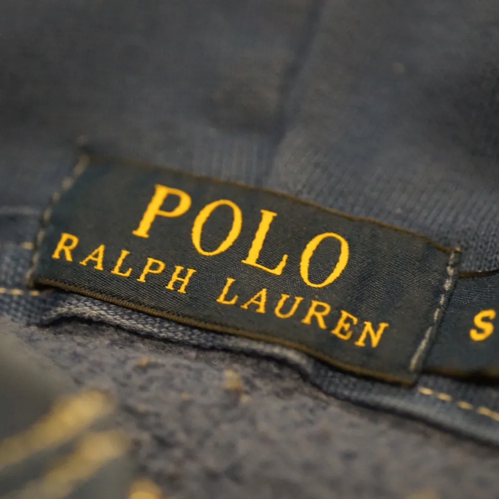 Säljer en snygg blå hoodie från Ralph Lauren i storlek S. Den har en dragkedja framtill och en klassisk broderad logga i rött på bröstet. Perfekt för höst, vinter och vår, med en skön passform och praktiska fickor. Huvan har vita snören för justering. Passar både till vardags och chill. Skick: 8/10. Tröjor & Koftor.