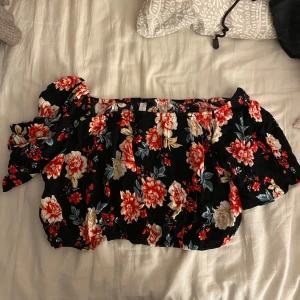 Blommig topp - Blommig topp som man kan ha of-sholder. Använd fåtal gånger och i mycket bra skick