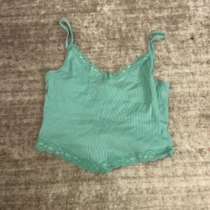 Mintgrön ribbad linnetopp från Terranova - Säljer en superfin mintgrön ribbad linnetopp från Terranova i storlek XS. Toppen har spetsdetaljer vid halsringningen och nederkanten, vilket ger den en söt touch. Perfekt för sommardagar eller som ett lager under en kofta. Använd ett fåtal gånger, så den är i mycket bra skick! Jag säljer den för den ligger bara i min garderob och jag andvänder inte den.