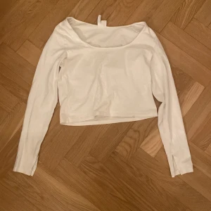 Vit långärmad topp från Divided - Säljer en stilren vit långärmad topp från Divided. Toppen har en enkel design med rund hals och är tillverkad i ett mjukt material som ger en bekväm passform. Perfekt för en avslappnad look.