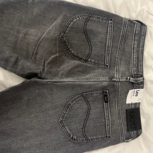 Helt nya gråa bootcut Lee jeans - Aldrig använda med lapp kvar, gråa Lee jeans med bootcut i storlek 29 och 31 i längd (se bild) endast på testade och säljes då dom var för stora på mig. Köpte för 1200 säljes för 750 + frakt. 