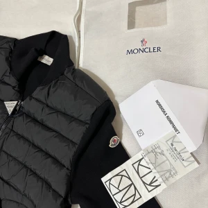 Svart jacka cardigan från Moncler - Säljer en stilren svart cardigan från Moncler. Använd fåtal gånger och fortfarande i splitter ny skick. Hör hjärna av er vid frågor.