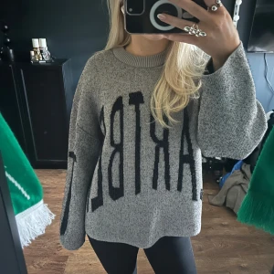 Grå oversized tröja med text - Säljer en grå oversized tröja med stor svart text på framsidan. Tröjan har långa ärmar och en rund halsringning. Perfekt för en avslappnad stil.