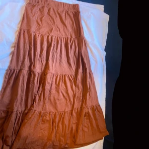 Orange/Brun långkjol från ONLY- Zalando - Säljer en snygg orange- brun långkjol från ONLY. Kjolen har en bekväm resår i midjan och är gjord i ett mjukt material. Jätte fin med en vit oversized skjorta inför sommaren.