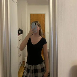 Svart body - Snygg svart body med tight passform. Perfekt för en stilren look. Bodyn har en enkel design som gör den lätt att matcha med olika outfits.
