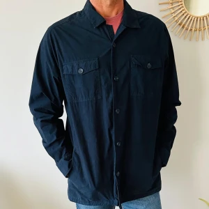 Jacka från Massimo Dutti - Säljer en stilren mörkblå jacka från Massimo Dutti. Den har långa ärmar och knappar framtill samt två bröstfickor med knappar. Perfekt för en avslappnad men ändå snygg look.