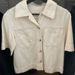 Beige kortärmad jacka från Norr - En stilren beige skjorta från Norr med korta ärmar och knappar framtill. Storlek XS💌