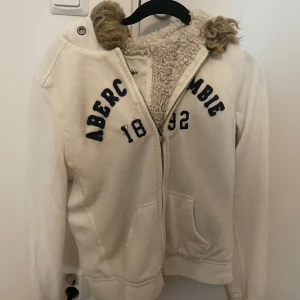 Vit hoodie från Abercrombie & Fitch - Säljer en vit hoodie från Abercrombie & Fitch. Storlek L men är liten i storlek. Pris går att diskutera